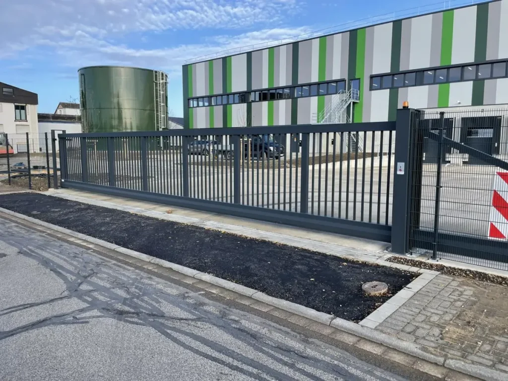 Einfahrtsbereich eines Logistikstandorts in Kerpen mit Schiebetor und Stahlmattenzaun; BETA ZAUN montierte den Zaun und stellte das Fundament für das Schiebetor her